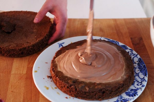 Two girls making a cake on the kitchen.