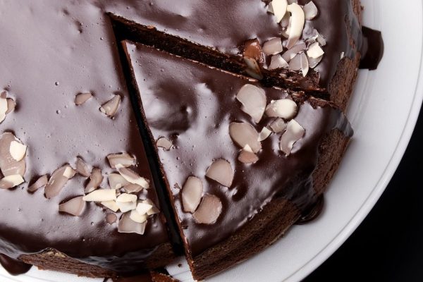 Chocolate cake with chocolate frosting on black background, top view