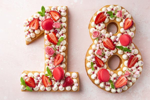 Number 18 naked honey cake for Birthday, pink background, top view