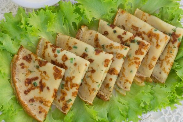 thin pancakes with greens on lettuce leaves