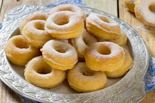 Donuts with powdered sugar on a wooden background. The concept of celebrating Chanukah, traditional Jewish sweet table.