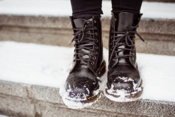 Black women's shoes on the stone steps covered by snow in the winter.