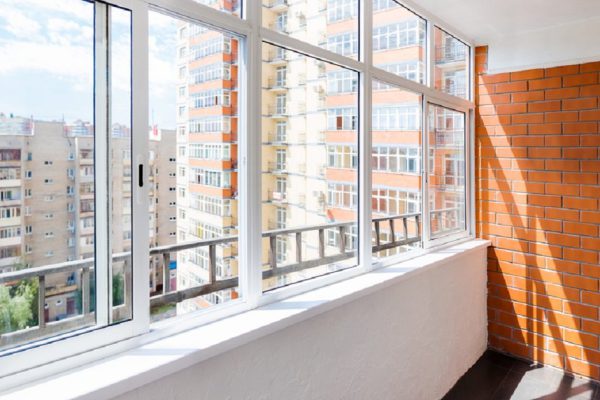 Glazed balcony with brick wall