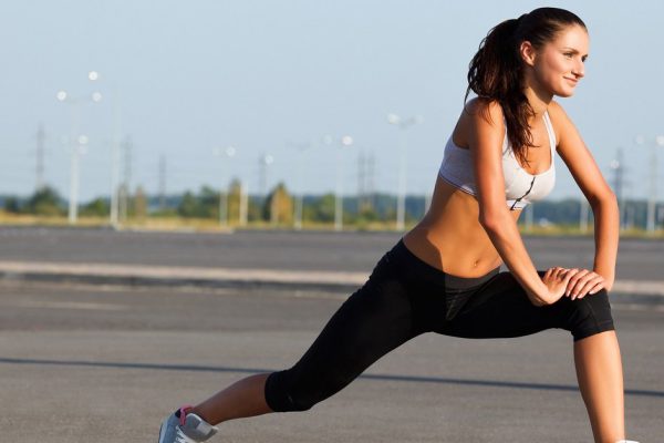 Portrait of Young Sporty Woman Doing Stretching Exercise. Athletic Workout.