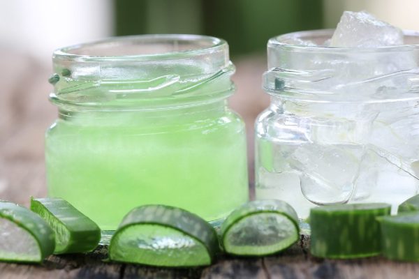 Fresh aloe vera and jelly in Glass bottle placed on a wooden floor and have copy space to input for design in your work.