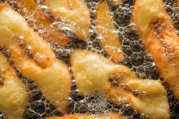 Frying delicious and traditionally donuts on hot oil