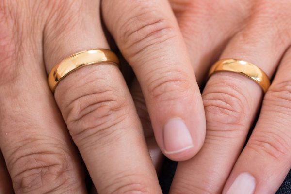 Close-up Of Hands With Golden Wedding Rings
