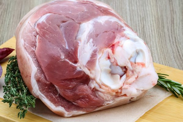 Raw pork knuckle with rosemary, thyme and onion - ready for coocking