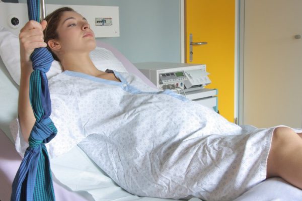 Young woman lying on a hospital bed in a delivery room