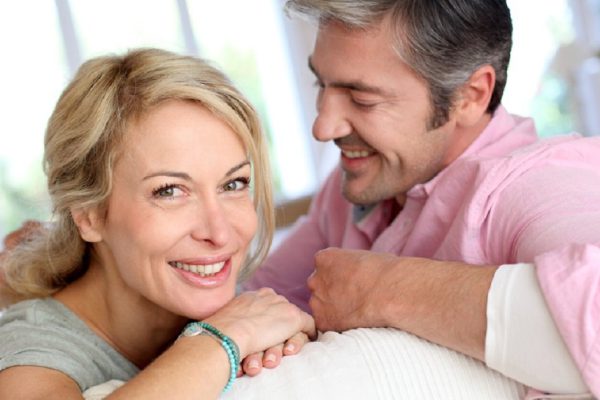 Middle aged couple relaxing in sofa at home