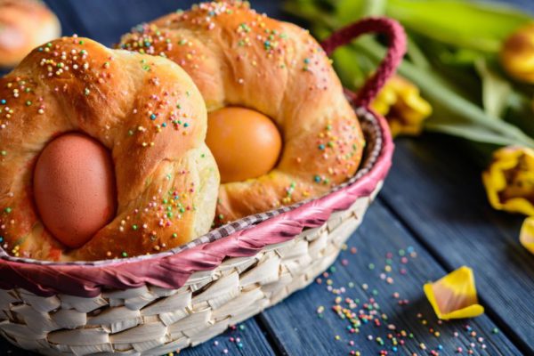 Traditional Italian Easter bread rings, decorated with eggs and colorful sprinkles