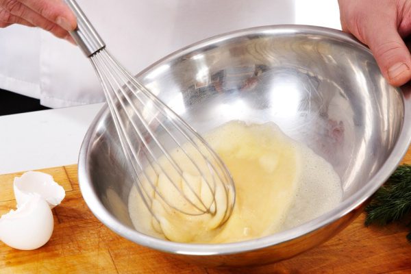 Image of cook hands whisking eggs for omelette