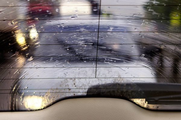 Kind on highway through wet glass