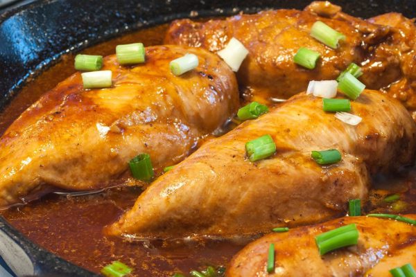 Chicken Breasts Cooking in a Cast Iron Pan with Green Onions