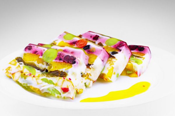 Pieces of jelly cake with fruits and milk in a white background