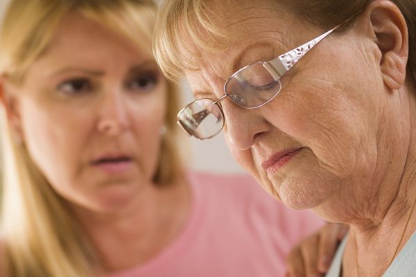 Young Adult Woman Consoles Sad Senior Adult Female.