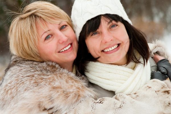 Two happy middle-aged women in winter nature