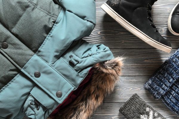 Women's warm winter clothing and accessories - jacket, black leather high top sneakers, gloves and hat. Wish list or shopping overview concept.  Fashion concept. View from above. Flat lay