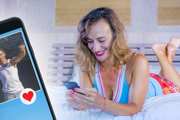 young attractive and happy girl smiling cheerful and relaxed using internet social media app on mobile phone on bed feeling relaxed enjoying at home bedroom in night gown on lifestyle concept